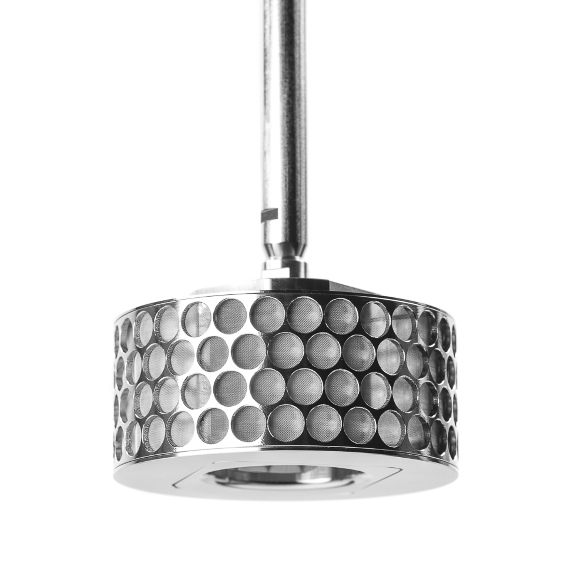 lose-up monochromatic image of a SpinChem rotating bed reactor showing a cylindrical stainless steel device with a honeycomb pattern of circular perforations filled with black catalyst material. The top features a threaded central mount with integrated filter system, demonstrating the reactor's sophisticated engineering for heterogeneous chemical reactions.