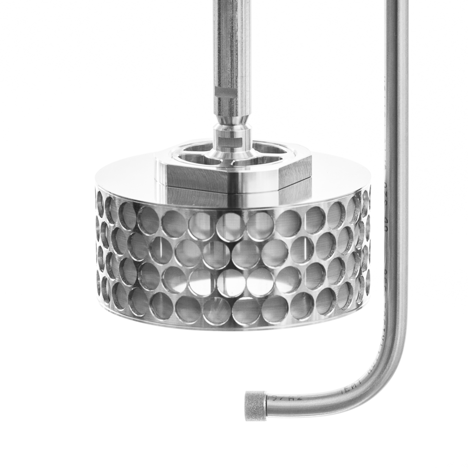 Side view of a stainless steel SpinChem rotating bed reactor featuring a cylindrical design with multiple perforated holes arranged in rows, connected to a vertical shaft and curved inlet pipe, shown against a white background.