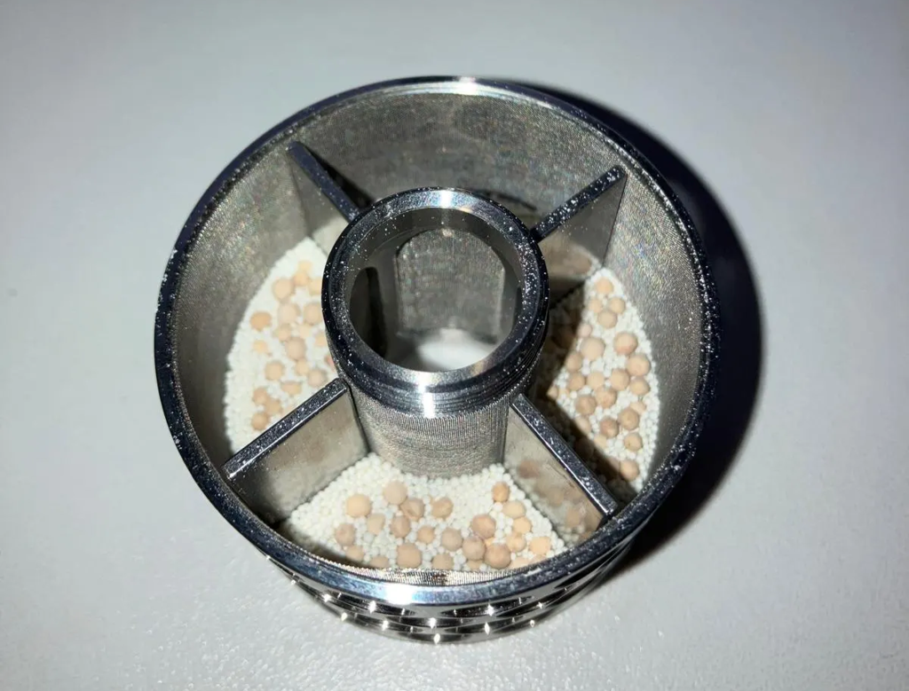 Immobilized enzyme beads loaded into the SpinChem rotating bed reactor (RBR). The RBR protects the catalyst beads during reaction.